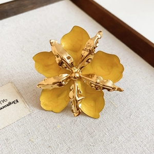 Primer plano detallado de un anillo de flor de esmalte amarillo vintage con pétalos dorados