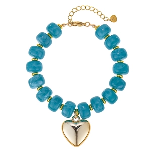 Detailweergave van een blauwe harskralenarmband met een grote gouden hartvormige hanger.
