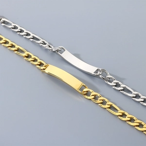 Detailed view of gold and silver Figaro chain bracelets with smooth curved plates