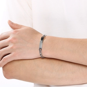 Close-up of minimalist titanium steel ID curb chain bracelet worn on wrist
