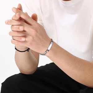 Close-up of a minimalist silver titanium steel curved plate bracelet on a wrist