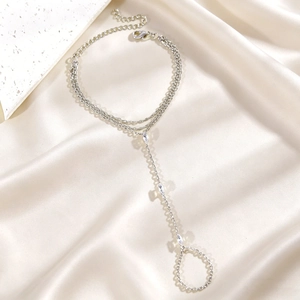 Vue détaillée d'un bracelet bague en argent avec zircon sur un tissu satiné élégant.