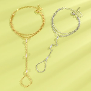 Gros plan de bracelets de doigt élégants en or et argent avec des zircons de taille marquise.