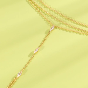 Détail d'une chaîne de doigt dorée avec d'élégants zircons de luxe taille marquise.