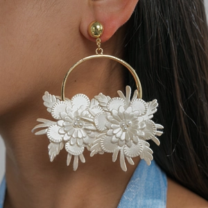 Detailed view of elegant cream leather flower hoop earrings worn by a female model