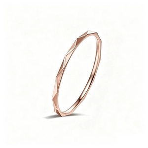 Vista dettagliata di un anello sottile in oro rosa con design geometrico a rombi.