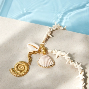 Close-up detail of starfish beads and shell pendants on a luxury titanium steel necklace