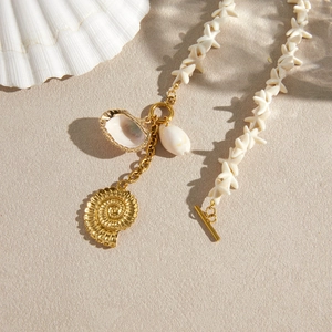 Detail view of a bohemian stainless steel shell necklace with golden nautilus pendant