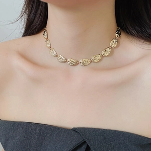 Nahaufnahme einer goldenen Vintage-Halskette mit strukturierten Metallblättern
