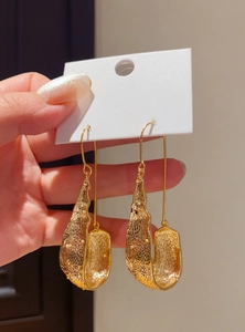 Detailed close-up of vintage style gold U-shaped dangle earrings with unique textured finish