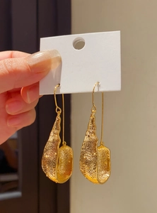 Detail shot of vintage gold U-shaped dangle earrings featuring a hammered metal texture