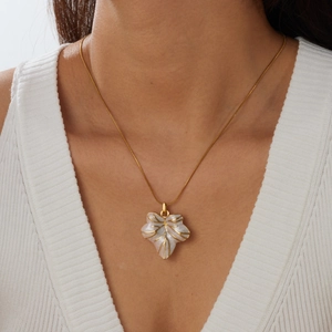 Elegante collana con ciondolo a foglia in acciaio inossidabile dorato su modella.