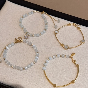 Close-up of four elegant cat's eye stone bracelets featuring various gold-plated designs.
