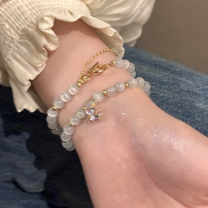 Detailed view of white cat eye stone bracelets featuring a sparkling star rhinestone charm