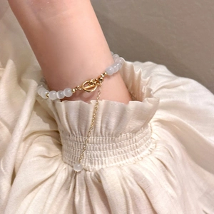 Elegant detail view of a cat eye stone bracelet with adjustable gold chain on wrist