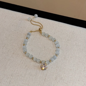 Detailed shot of cat-eye stone adjustable bracelet with a sparkling diamond charm