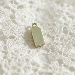 Close-up of a stainless steel pendant with light green enamel inlay on white lace