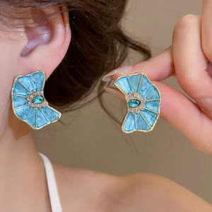 Primer plano de elegantes pendientes de flor azul con centro de cristal