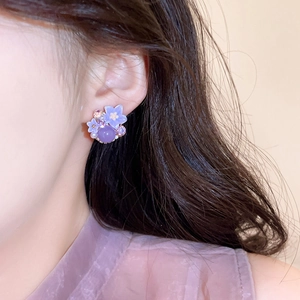 Detailopname van elegante paarse bloem oorknopjes met glinsterende micro-kristallen en parels