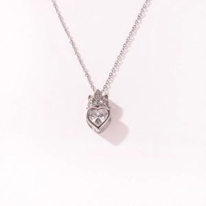 Gedetailleerde macro-opname van hartvormige kristallen hanger ketting met kroon ontwerp, zilver.