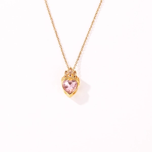 Detail van hartvormige roze edelsteen hanger met elegante gouden kroon zetting