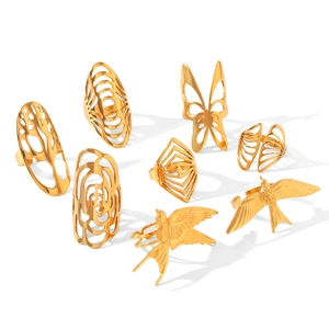 Detailed view of assorted gold stainless steel rings with hollow bird and butterfly designs.