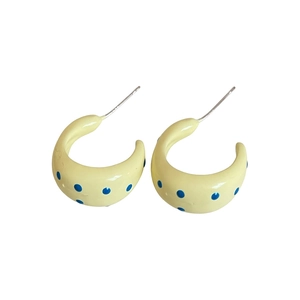 Pendientes de aro en C de color amarillo pálido con lunares azules y postes de plata
