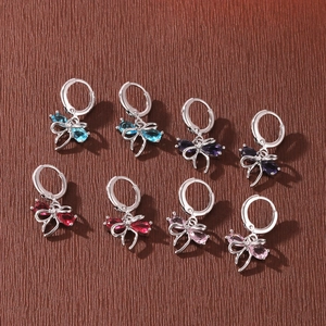 Detailed view of minimalist bow knot hoop earrings with sparkling multi-colored zircons