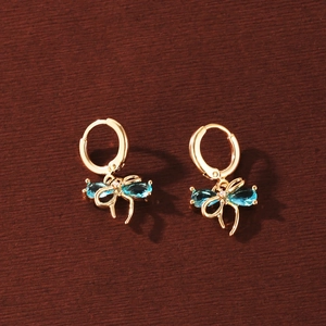 Close-up view of elegant gold-plated bow hoop earrings with sparkling blue zircon stones