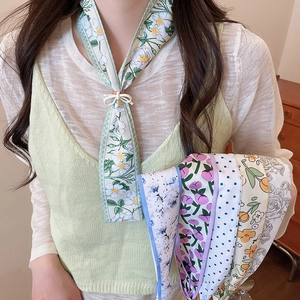 Close-up of several elegant floral silk scarf necklaces worn by a fashion model in detail