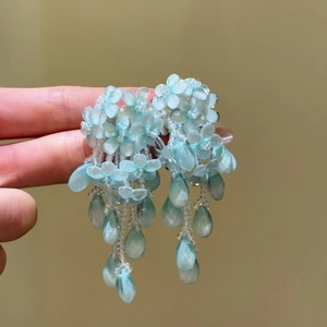 Vue détaillée de boucles d'oreilles pendantes à fleurs bleues pour une ambiance d'été.