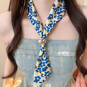 Close-up detail of a French style floral silk scarf necklace with a pearl ring accent