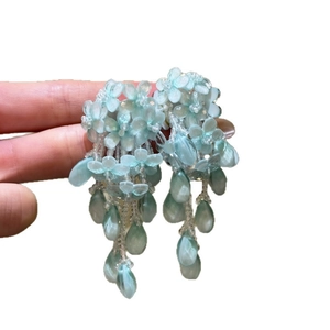 Élégantes boucles d'oreilles fleur en verre bleu clair avec pendentifs goutte.