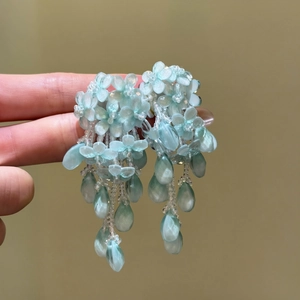 Vue détaillée de boucles d'oreilles à pompon en perles bleues pour un look printanier