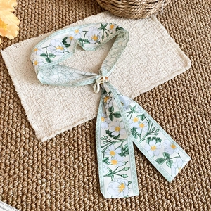 Detail of French floral silk scarf necklace with tulip pattern and decorative buckle