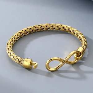 Primo piano del bracciale in corda d'acciaio intrecciata dorata con chiusura a infinito