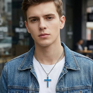 Vue détaillée du pendentif croix en acier bleu et argent sur un mannequin masculin.