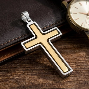 Vue détaillée d'un pendentif en forme de croix bicolore en acier inoxydable