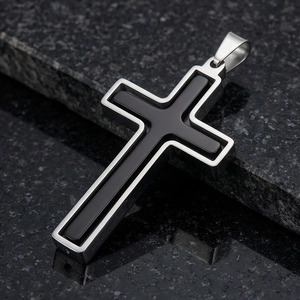 Détail d'un pendentif croix en acier inoxydable bicolore avec incrustation noire
