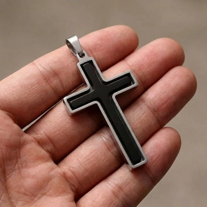 Vue rapprochée d'un pendentif en forme de croix rotative en acier inoxydable argent et noir