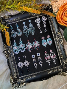 Detaillierte Kollektion von Vintage-Ohrhängern mit bunten Zirkonen auf Tablett.