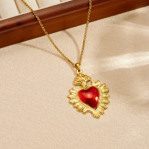 Primo piano di una collana in acciaio inossidabile dorato con ciondolo a cuore rosso