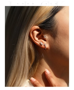 Detail shot of a woman wearing silver moissanite crescent moon and teardrop earrings