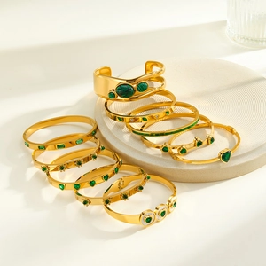 Detailed view of stackable gold-plated stainless steel bangles with malachite and shell