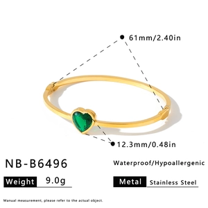 Detail view of gold stainless steel bangle featuring a green heart stone and measurements