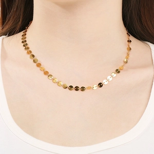 Minimalist shiny gold stainless steel sequin disc chain necklace worn by a female model