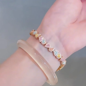 Gros plan d'un bracelet plaqué or rose avec des zircons colorés en forme de goutte d'eau