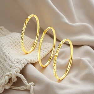 Detailed view of 1mm gold-plated stainless steel stackable rings with geometric patterns