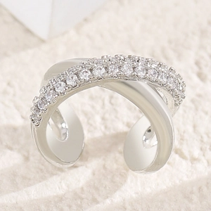 Close-up of elegant X-shaped ear cuff with sparkling cubic zirconia stones.