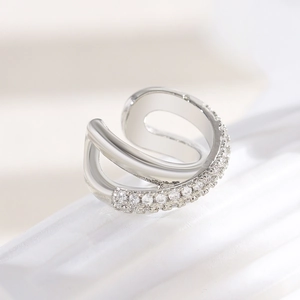 Close-up view of a silver-toned criss-cross ear cuff set with sparkling cubic zirconia stones.